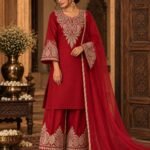 Red cotton kurta set with Washed Gold Tilla Dozi embroidery on the neckline, sleeves and palazzo, paired with a red net dupatta with piping. Traditional Kashmiri-inspired festive ethnic wear.